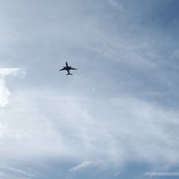 頭上を飛んで行く大型旅客機と青空の白い雲の写真