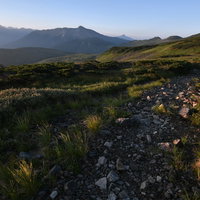黒部五郎岳へと向かう稜線の登山道と夕焼けの風景の写真