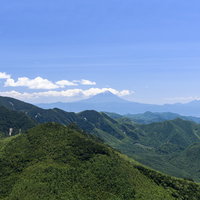 瑞牆山の山頂から見える富士山と連なる山々のパノラマの写真