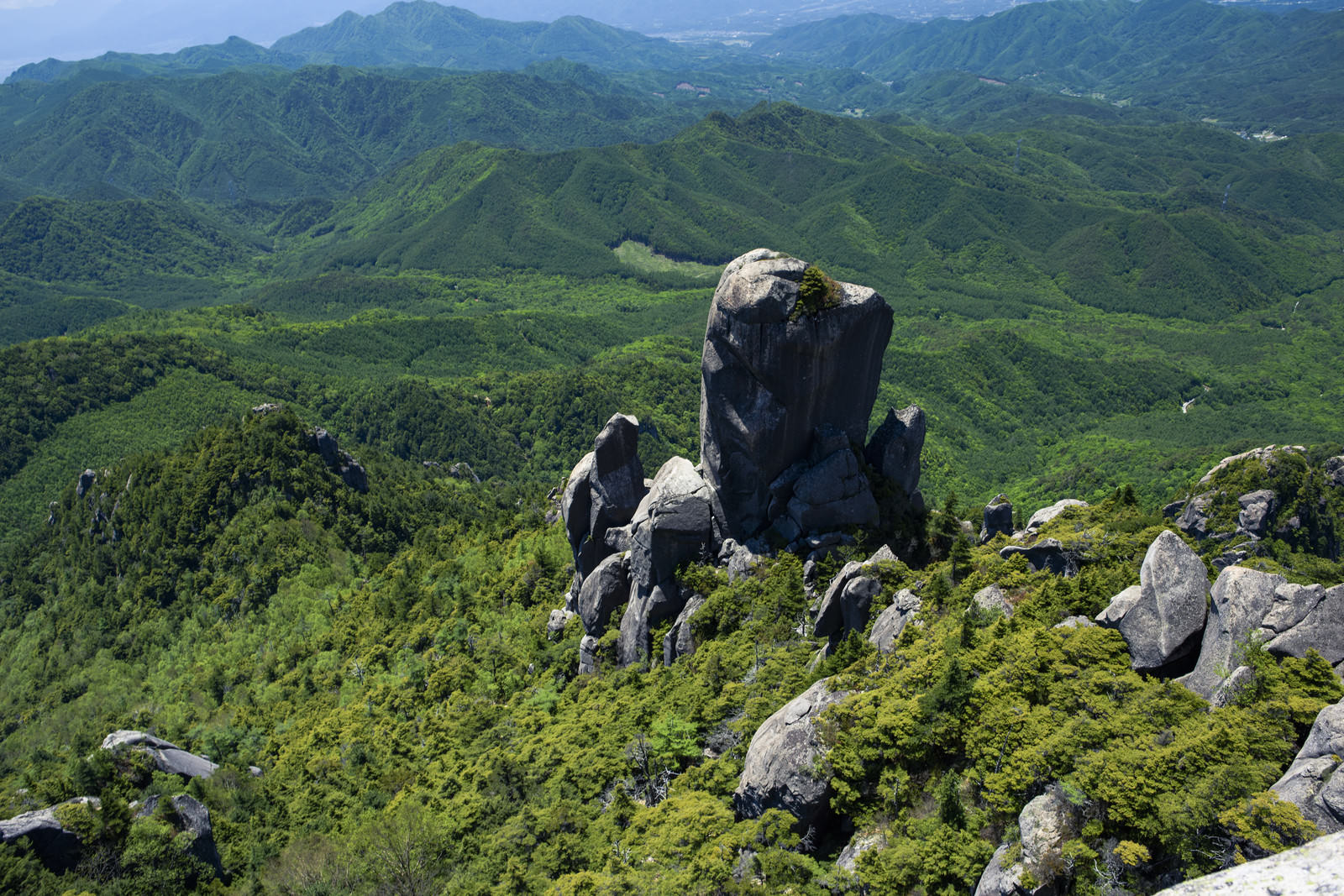 緑の山々を背景に聳え立つ瑞牆山の大ヤスリ岩の巨石群