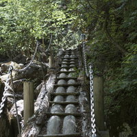 鎖の手すりで渡る瑞牆山の登山道、急な岩場と木製桟道の写真