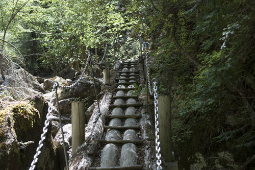 鎖の手すりで渡る瑞牆山の登山道、急な岩場と木製桟道