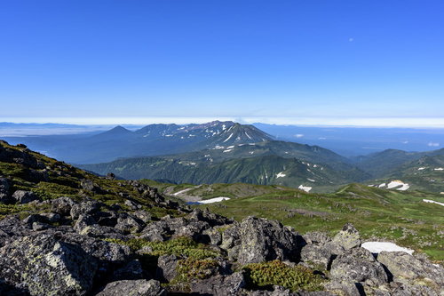 トムラウシ山頂の岩場から十勝岳方面を望む雄大な山並み