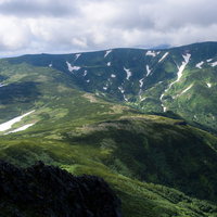 大雪山系の化雲岳、緑の山稜に雲が迫る景観の写真