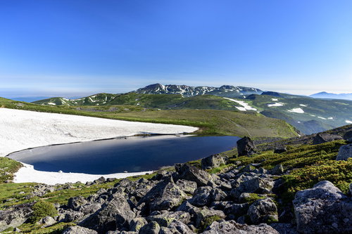 大雪山北沼と残雪を抱いた大雪山の山々、トムラウシ山の雄大な景色