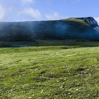 大雪山の草原から眺める忠別岳と青空の山岳風景の写真