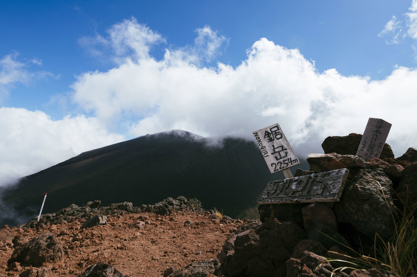 鋸岳山頂標識と雲の巻く山体