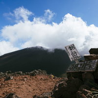 雲海と青空に映える鋸岳の登頂標の写真