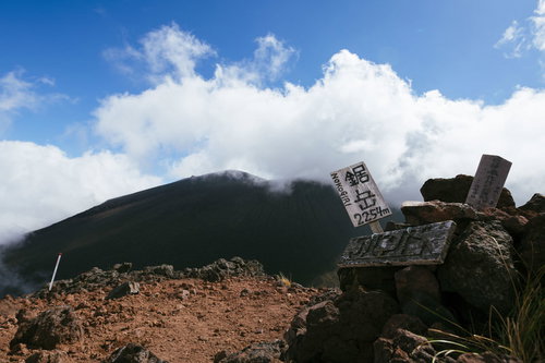 雲海と青空に映える鋸岳の登頂標