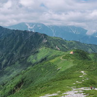 種池山荘と立山連峰の山々が連なる稜線と登山道の眺望の写真