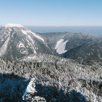 北横岳から見る冬の蓼科山の雪化粧と周辺山々の写真