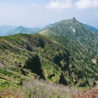 沖武尊から見る剣ヶ峰と連なる山々の稜線と青空の写真