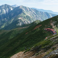 五竜岳の稜線に建つ五竜山荘と白馬岳方面の景観の写真