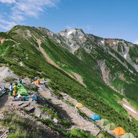 五竜山荘周辺に張られたカラフルなテントと五竜岳の景観の写真