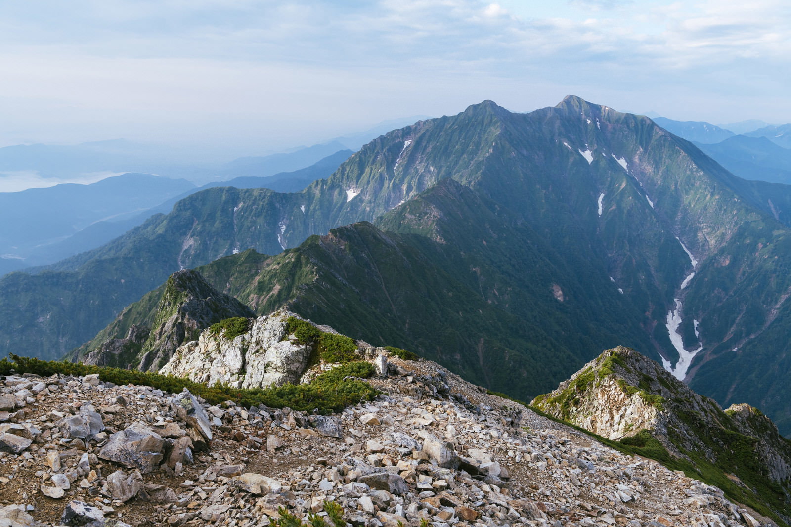 八峰キレットの岩場越しに見える鹿島槍ヶ岳の雄大な山容