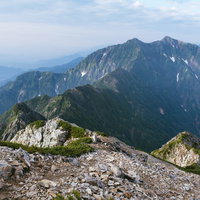 八峰キレット越しに見える鹿島槍ヶ岳と北アルプスの稜線の写真