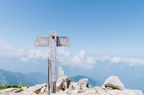 北アルプス唐松岳山頂の白い指導標と五竜岳の眺望