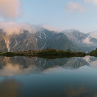 朝焼けの白馬と五竜岳を写す八方池の水鏡リフレクションの写真