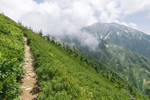 牛首下部から見る雲に包まれた五竜岳と登山道
