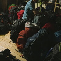 日本百名山・五竜岳の山小屋で登山者のザックを並べる小屋番の写真