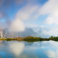 雲が躍る朝の八方池と五竜岳の水鏡の写真