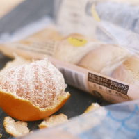 ハイキング用に準備された剥きかけのオレンジと菓子パンの写真