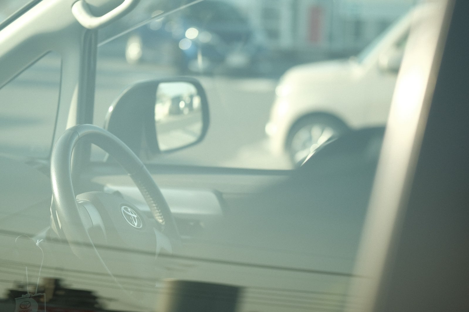 車の運転席からの視点でハンドルと窓ガラスが見える車内