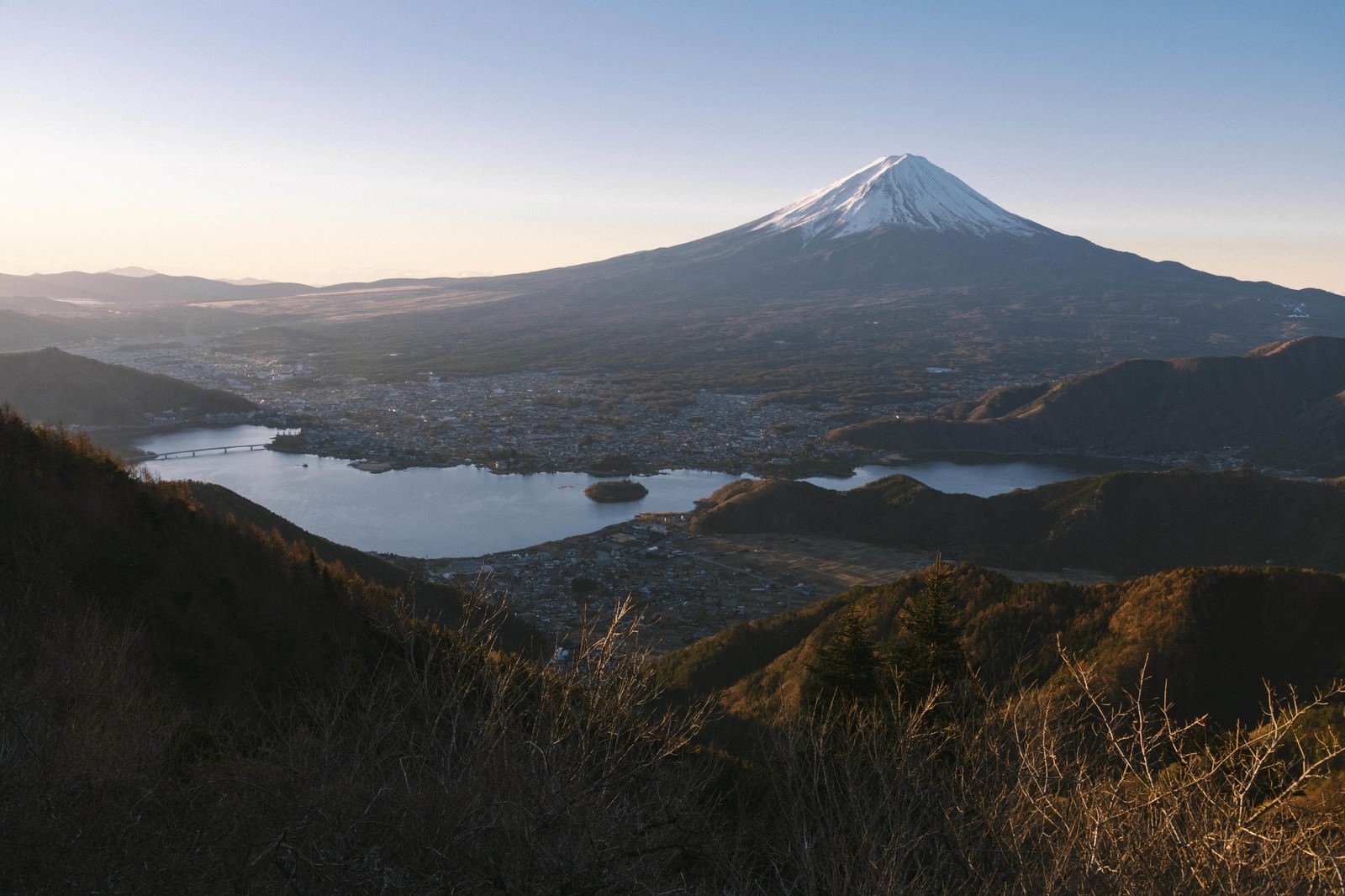 新道峠から見る朝焼けの空に映える富士山と湖、森林の風景