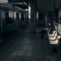 駅のホームで夕暮れ時に仕事をするビジネスマンの写真