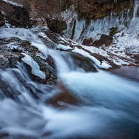 冬の横谷渓谷の渓流に垂れ下がるつらら氷柱の写真