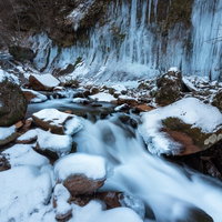 冬の横谷渓谷の渓流に垂れ下がるつらら・氷柱風景の写真