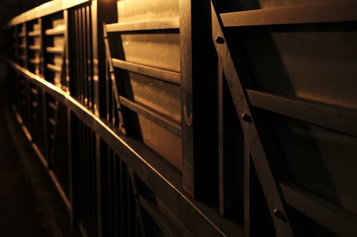 夕日に鈍い光を放つ鉄の壁と骨組み構造