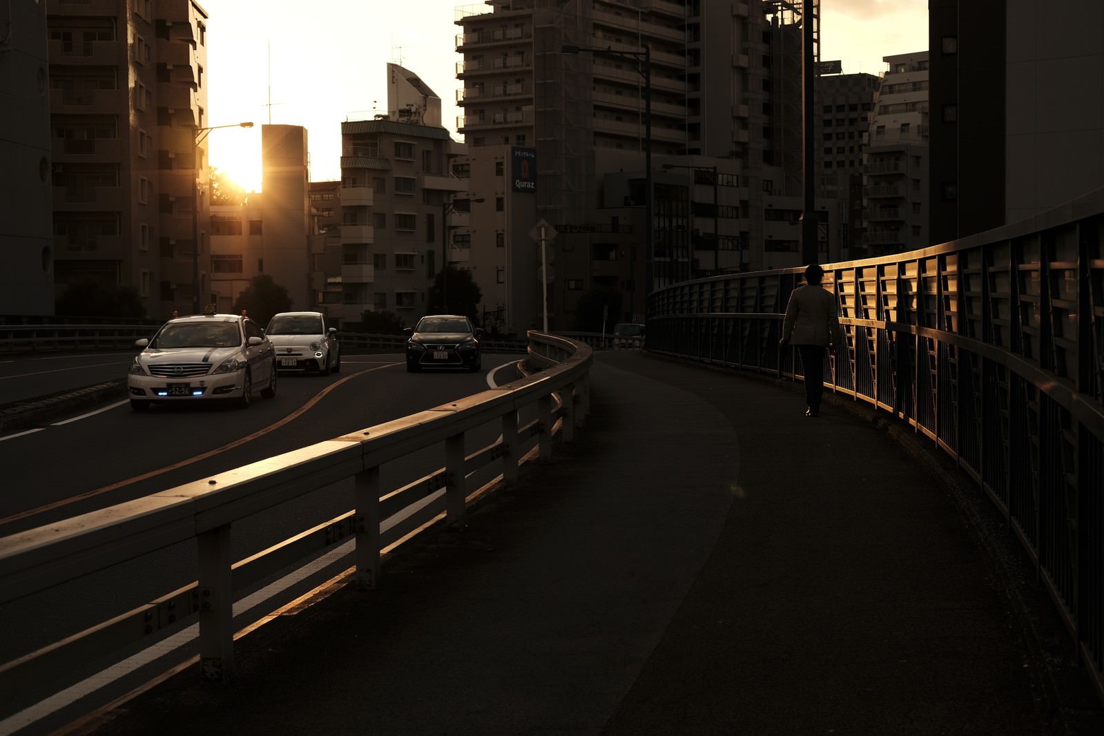 夕日が沈む街並みで車道と歩道が見える夕暮れの都市風景