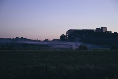 夕暮れの河川敷を散歩する人のシルエット