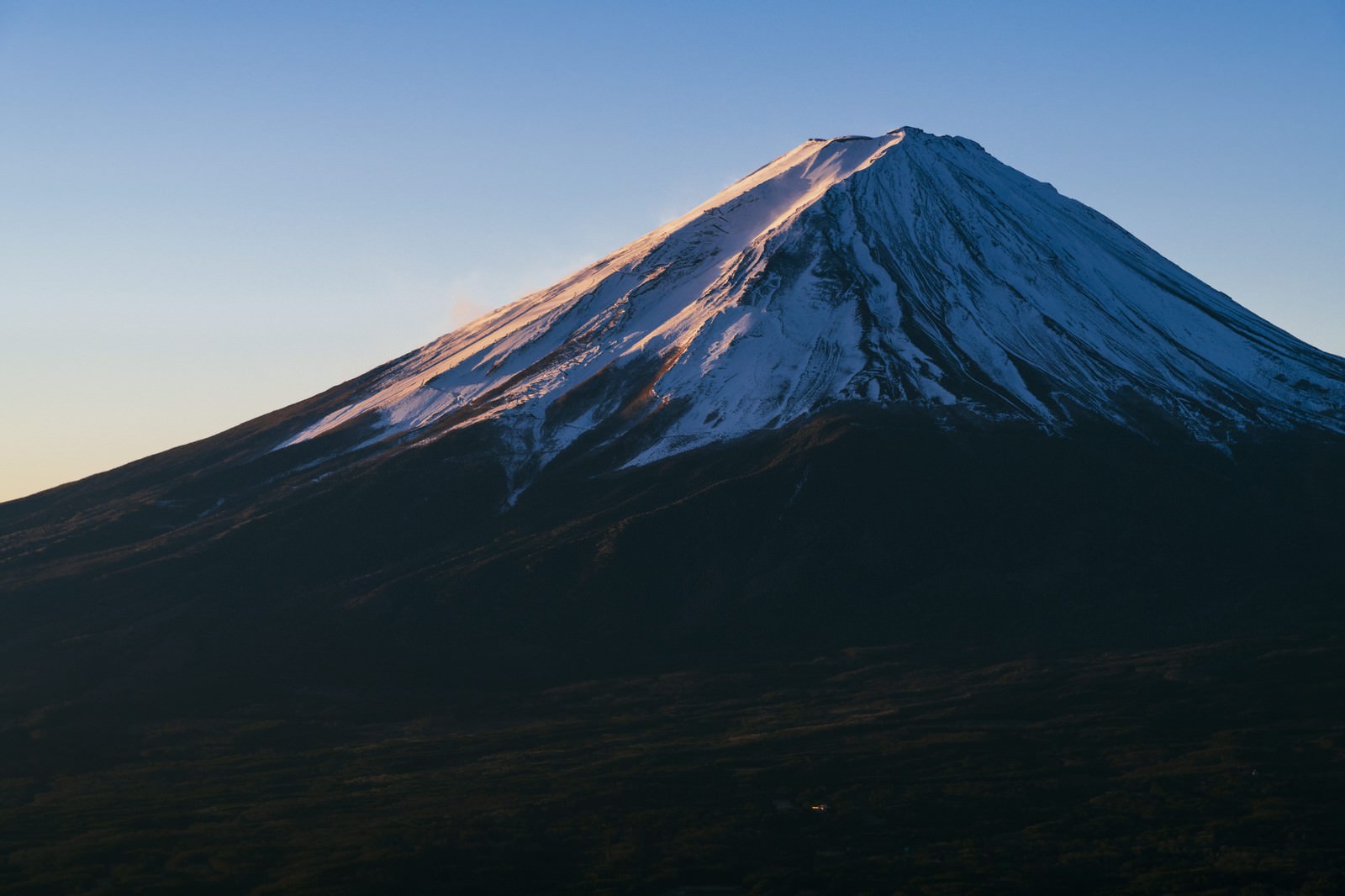 朝焼けのオレンジ色に染まった富士山の山頂部分