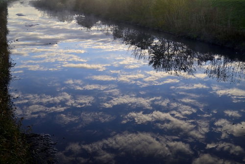 川霧の中で水鏡に映る千切れ雲の風景