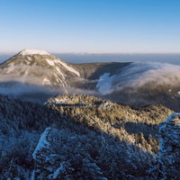 雪化粧した蓼科山を通り過ぎる冬の滝雲の写真
