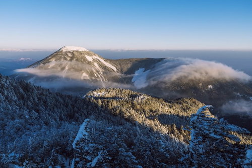 雪化粧した蓼科山を通り過ぎる冬の滝雲