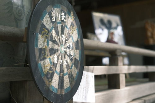 神社の境内に置かれた木製の円形ダーツボード