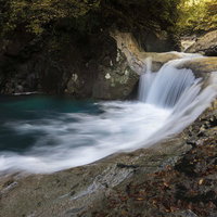西沢渓谷のエメラルドグリーンに輝く渓流と滝壺の写真