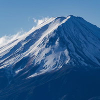 冬の青空に雪煙を上げる富士山、日本百名山の雪化粧した山頂の写真
