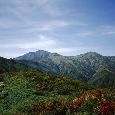 古寺山から見る大朝日岳の稜線と青空の山々の写真