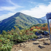 古寺山の山頂標から見る小朝日岳と大朝日岳の写真