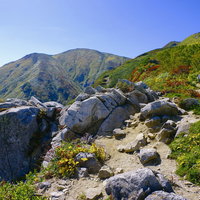 大朝日岳の岩場の登山道を下山してくる登山者の写真