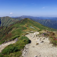 大朝日岳山頂付近の稜線沿いに続く登山道と周囲の山々の写真