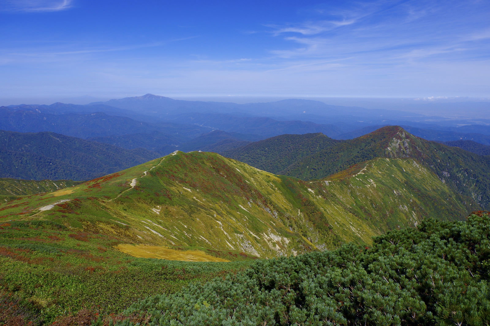 大朝日岳から小朝日岳へと続く緑の稜線と青空が広がる山岳風景