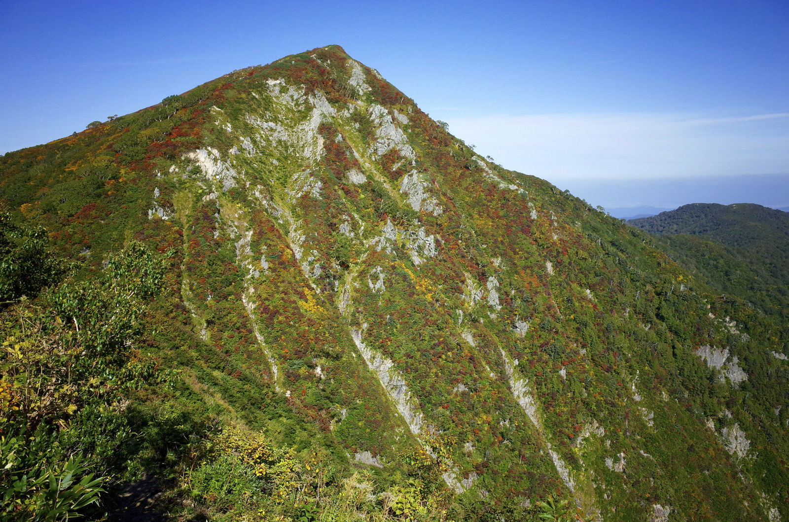 紅葉に染まった小朝日岳と奥に見える大朝日岳の稜線
