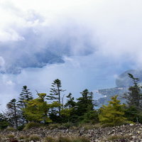 男体山山頂から見る雲に覆われた中禅寺湖（ちゅうぜんじこ）の写真
