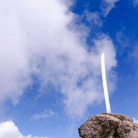 男体山山頂の岩場に立つ刀剣と青空の絶景の写真