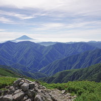 聖岳から望む南アルプス南部の山並みと富士山の写真